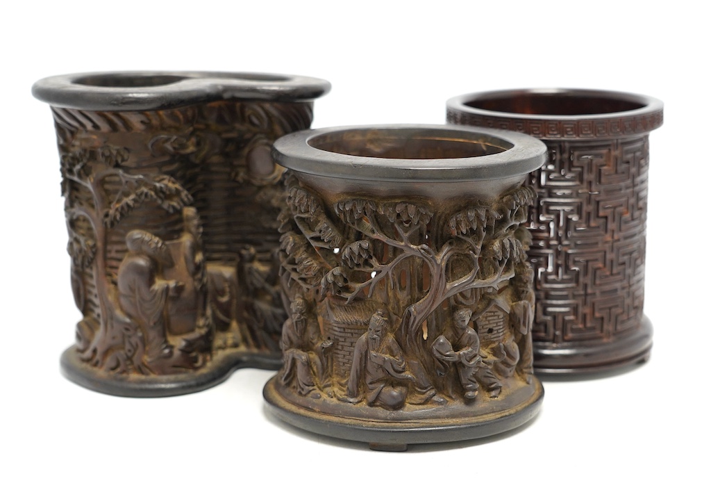 Two finely carved Chinese bamboo brush pots, and a reticulated hardwood brushpot, largest 14.5cm high. Condition - bamboo pots with cracks